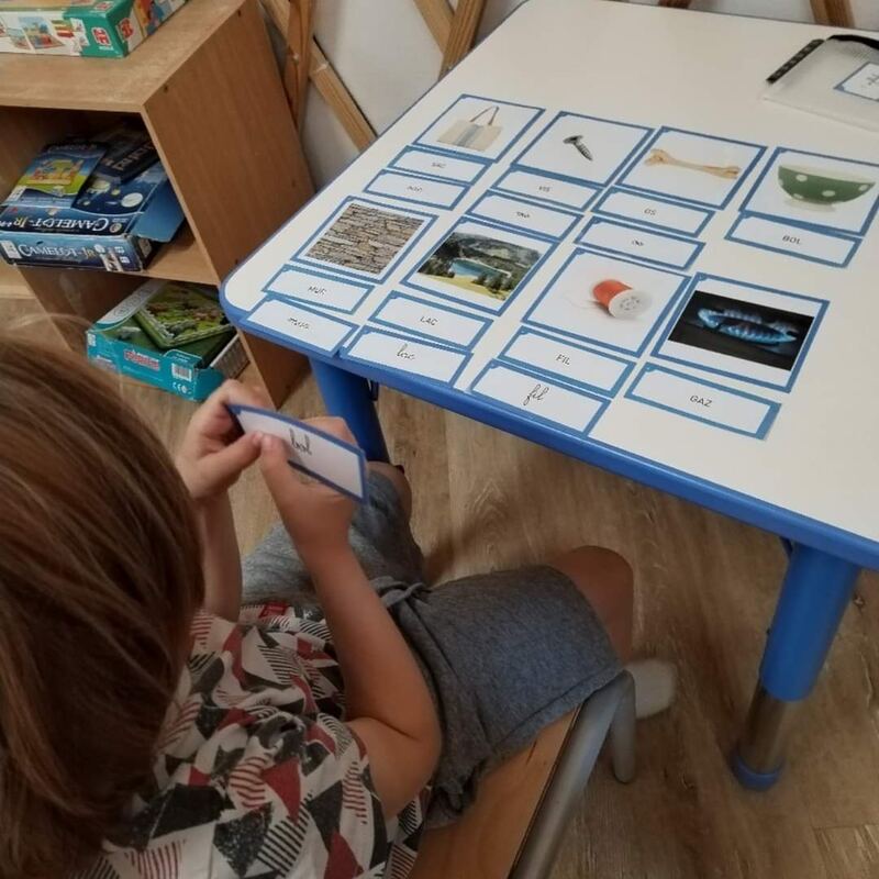 Un enfant associe des cartes images et des étiquettes de mots