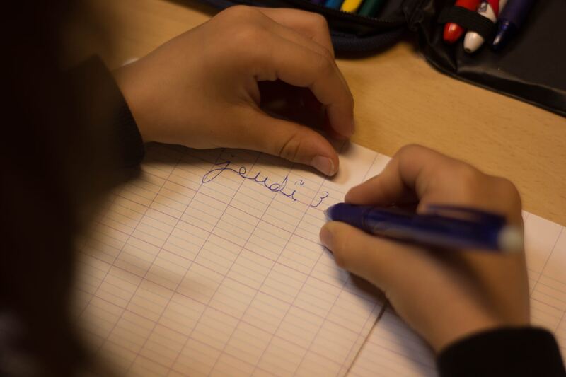 Un enfant écrit dans son cahier